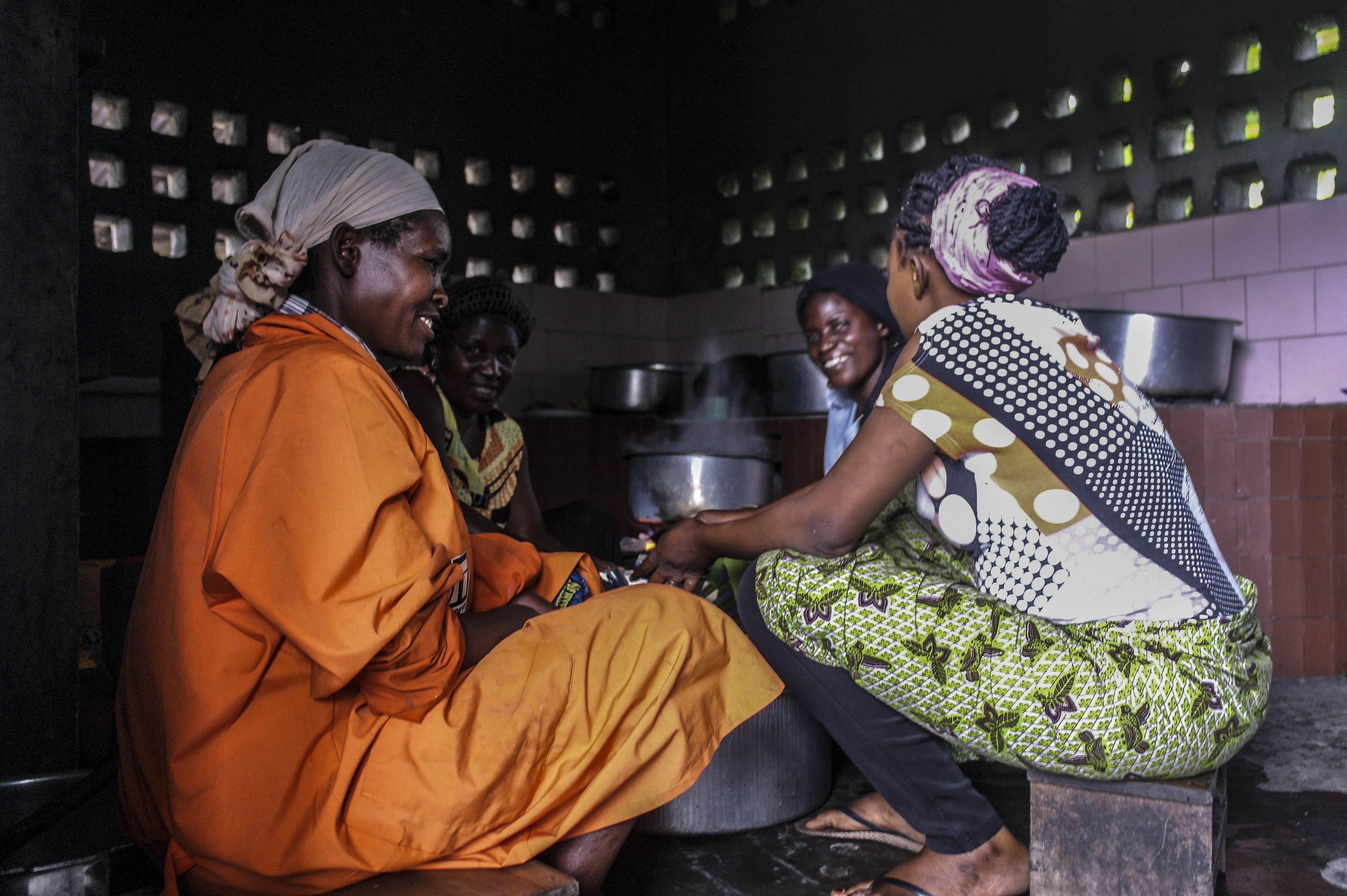 Dans la convivialité, des malades en voie de guérison et le personnel de service de l’hôpital ensemble font à manger pour les malades dans la cuisine