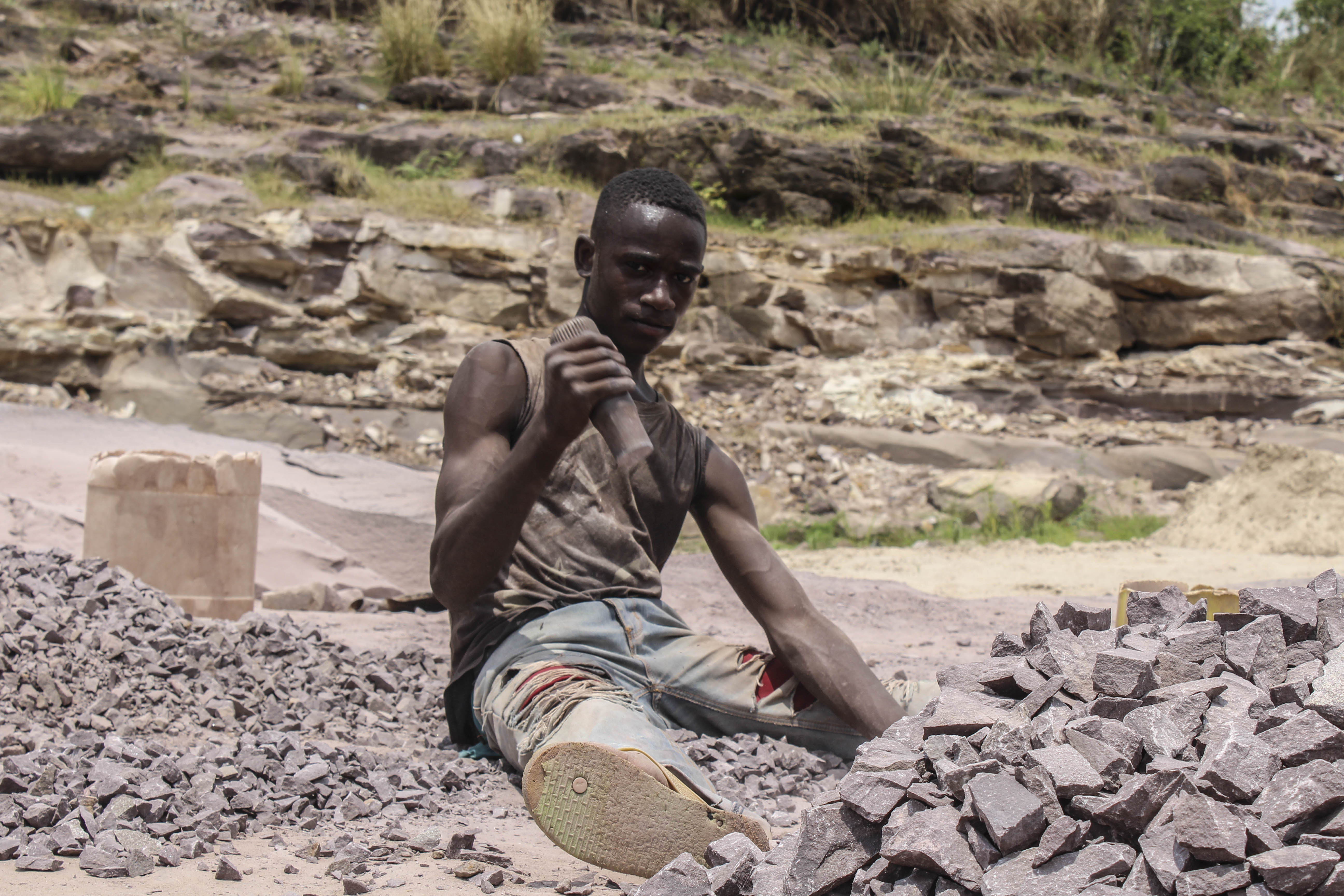 Un adolescent qui concasse des roches à Mont Ngafula