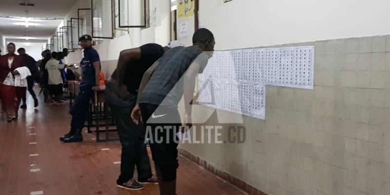 Un électeur qui cherche son nom sur les listes affichées au bureau de vote.