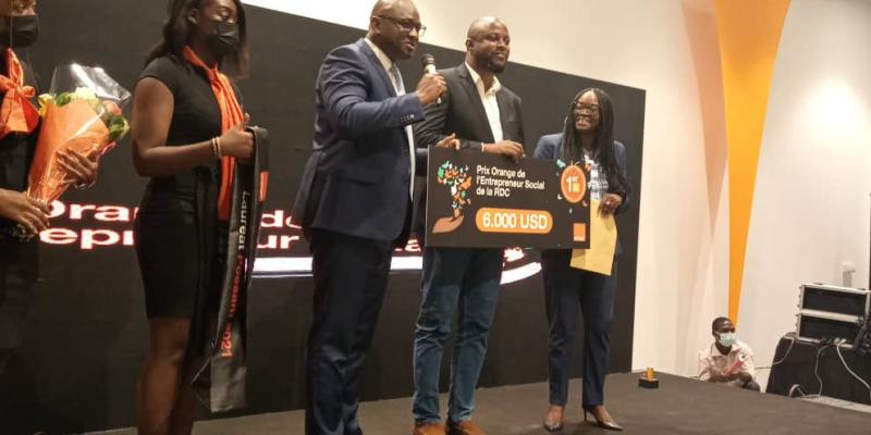 De gauche à droite, deux hôtesses, deux filles à gauche sont des hôtesses, Ben Cheick Haidara DG de Orange RDC, Baya Ciamala, vainqueur et Mireille Kabamba DG de Canal+ et Présidente du jury