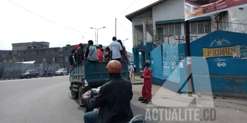 Les gens recourant à des camions de marque Ben et des tricycles comme moyen de transport