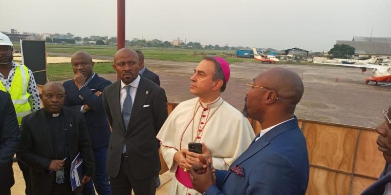 Patrick Muyaya et Mgr Ettore Balestrero (Nonce apostolique) à l’aéroport de Ndolo