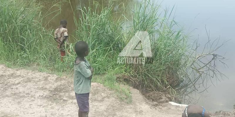 Trois enfants au bord de la rivière N'djili se livrant à la pêche 