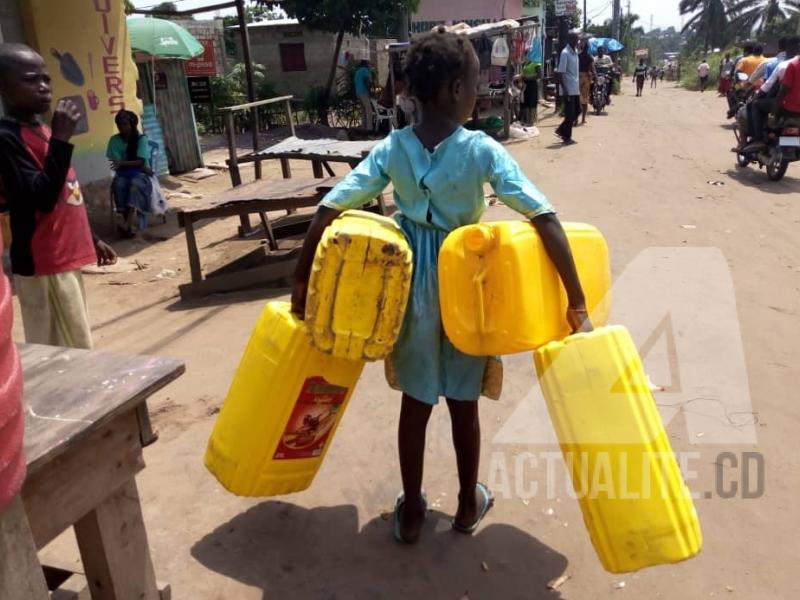 Dorcas, fillette de 7ans qui va puiser de l'eau avec ses bidons de 25 litres