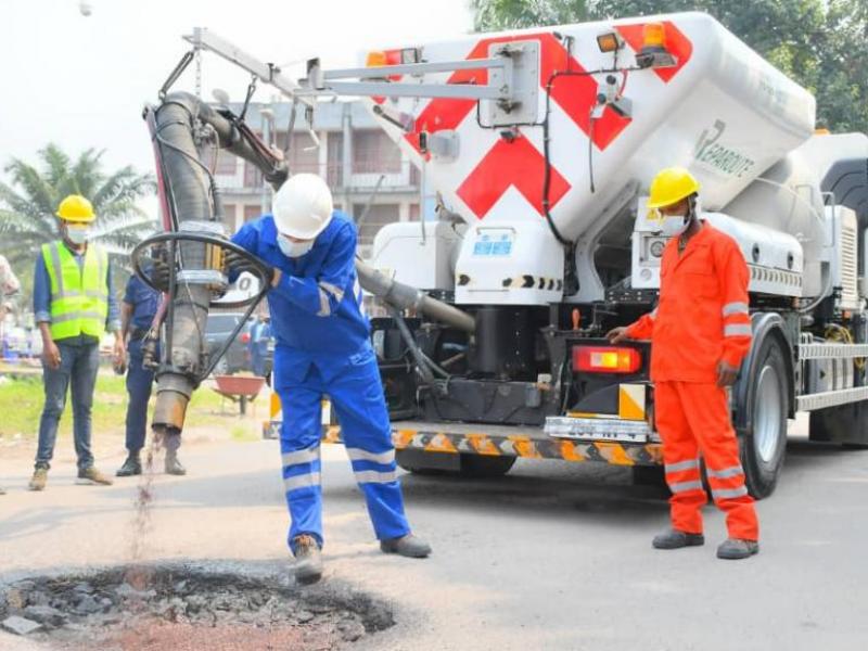 Démonstration de remplissage d'un nid de poule à Kinshasa