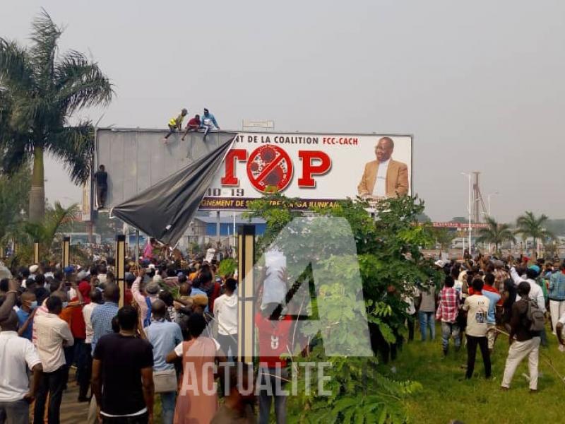 Les militants de l'UDPS devant le panneau portant effigie du premier ministre au palais du peuple. Photo ACTUALITE.CD.