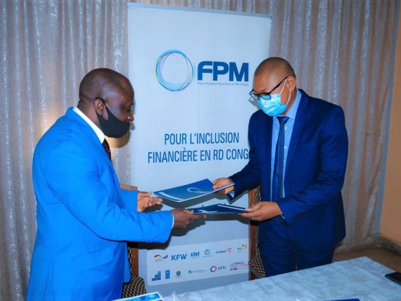 Le  Gérant de la CAMEC, M. Masha MATONDO, à gauche, et Mr Carlos KALAMBAY KABANGU, DG du FPM SA, à droite, lors de la signature du contrat de financement.