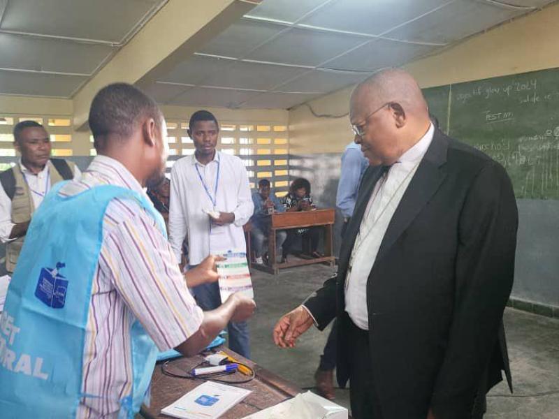 lE Cardinal Fridolin Ambongo dans un bureau de vote