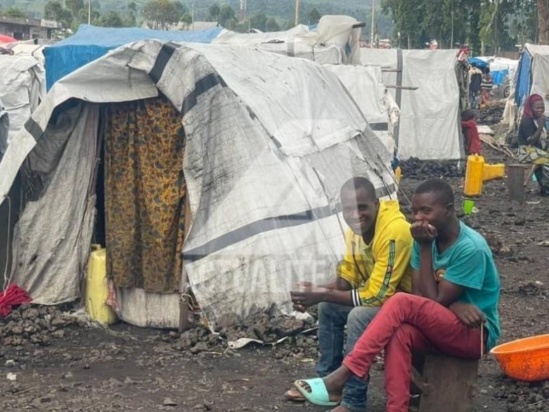 Des jeunes déplacés devant leur cabane sur le site de Kanyaruchinya