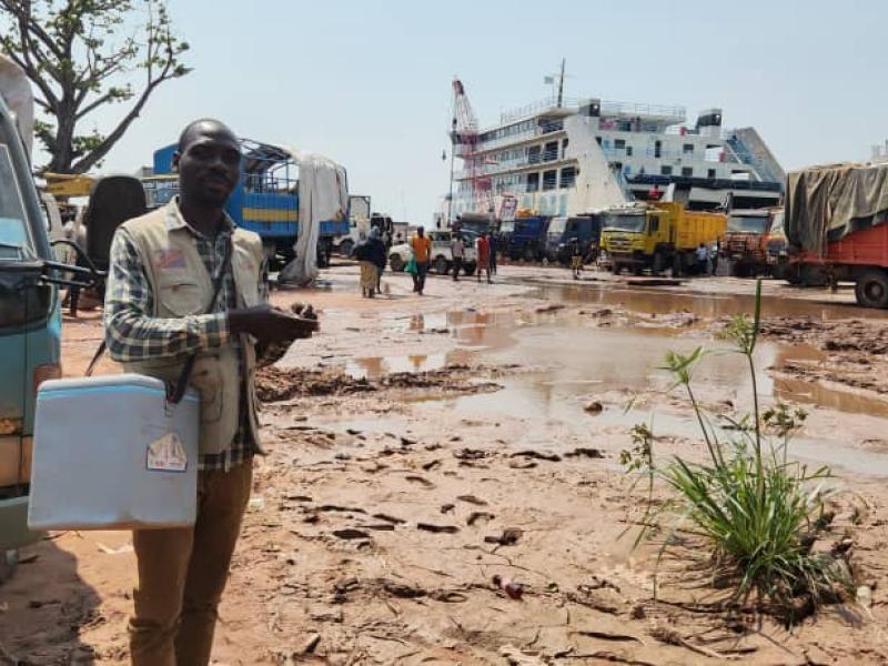 John, mobilisateur communautaire au port de la SNCC de Kalemie dans le Tanganyika, parcourt les alentours du port avec sa glacière de vaccins, à la recherche des familles voyageant avec des enfants pour les vacciner