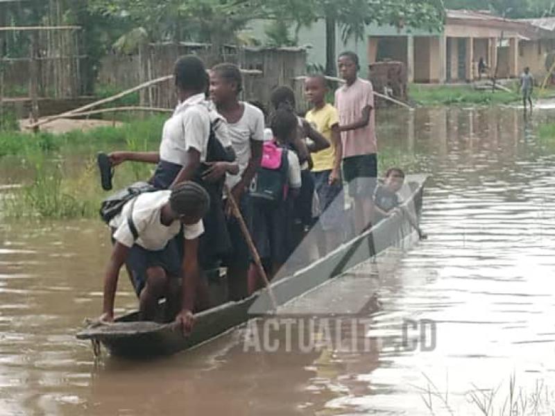 Des écoliers dans une pirogue de fortune pour faire face aux inondations à Isangi